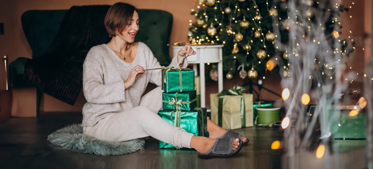 woman wearing arch support slippers and packing gifts for christmas 2025