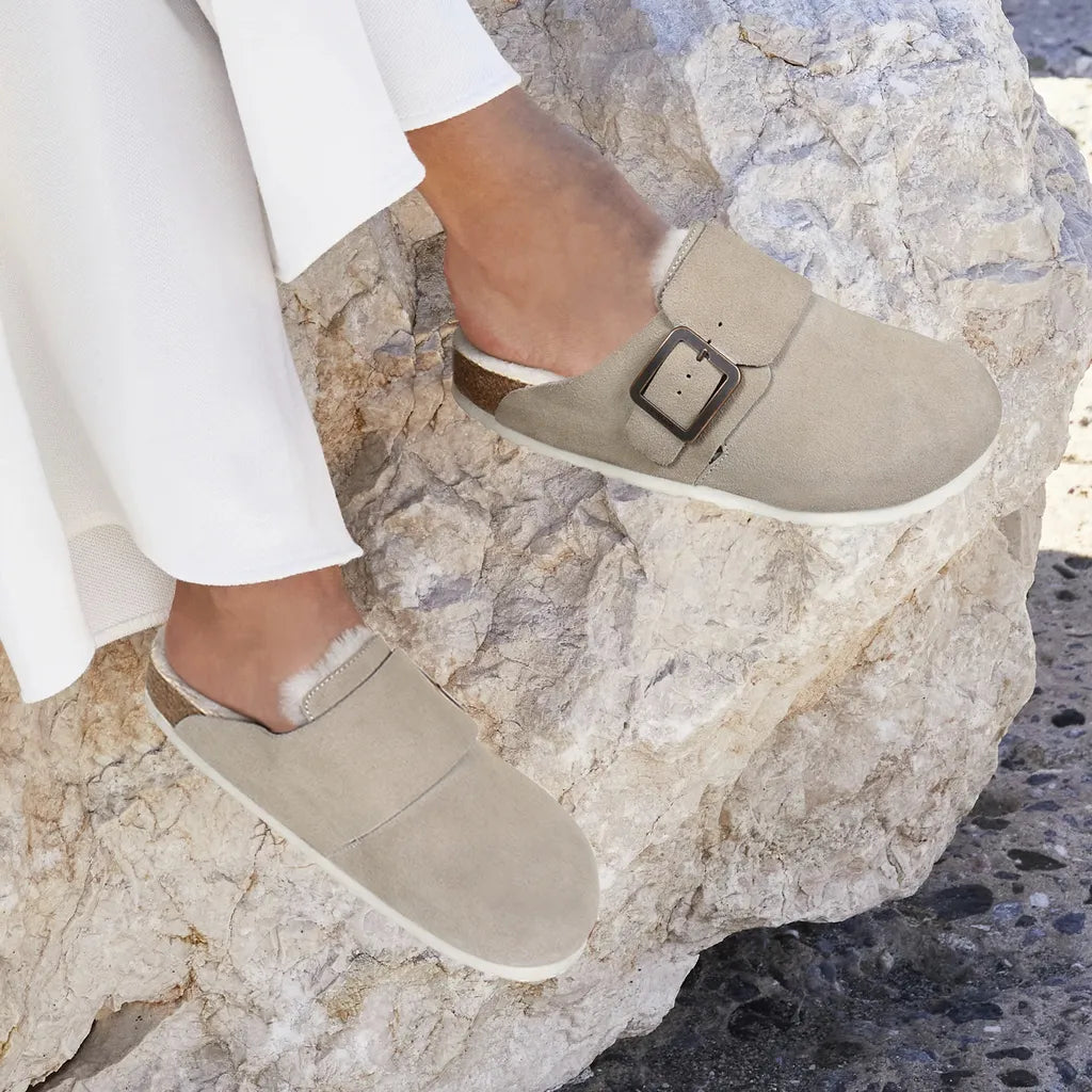 Beige slip-on shoes with a buckle on a rocky surface
womens clogs