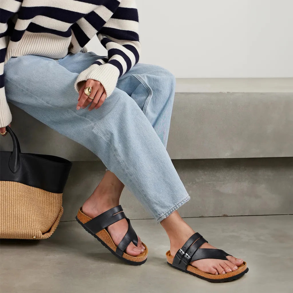 Person wearing black sandals with brown soles, sitting on a concrete surface.
cork sandals
cork sandals womens
cork bed sandals women