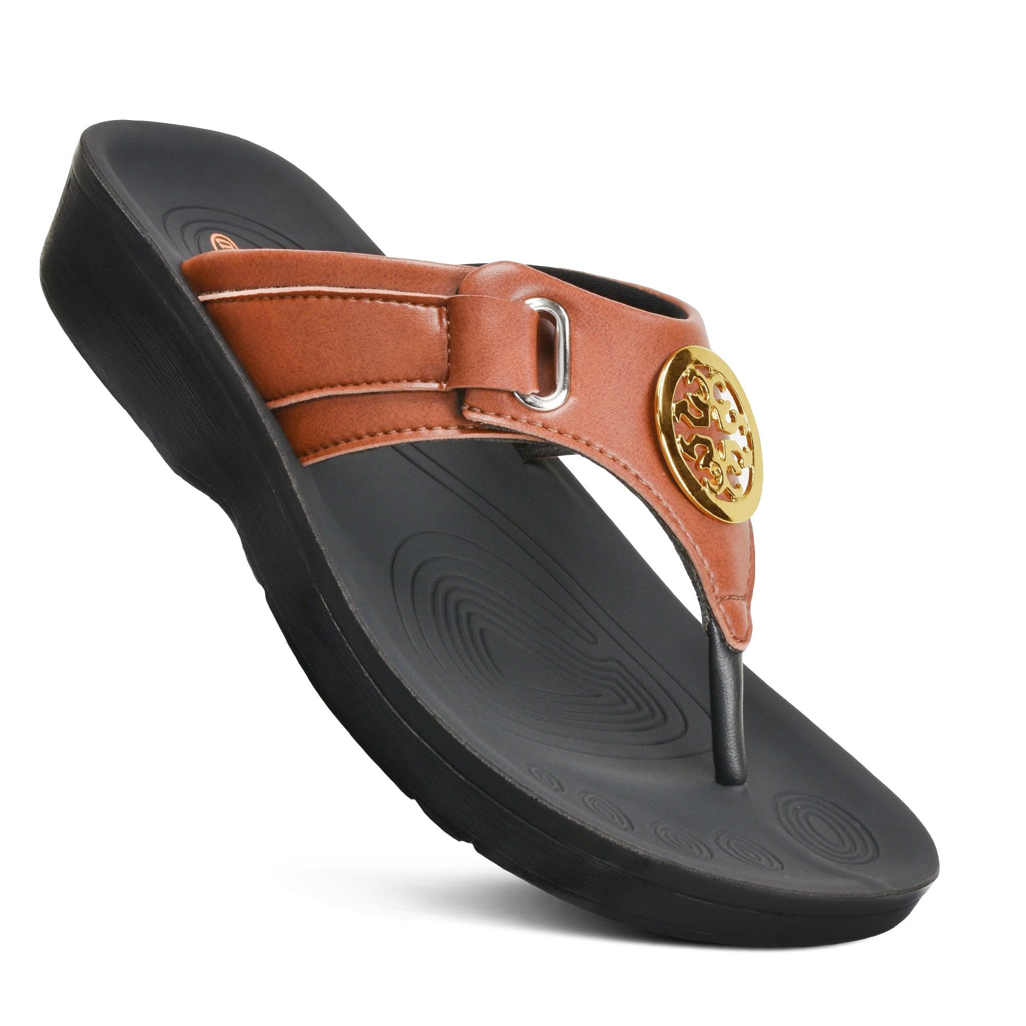 A women's sandal with a metallic ornament on the upper, featuring a black strap and a green-toe ring, set on a black platform sole.