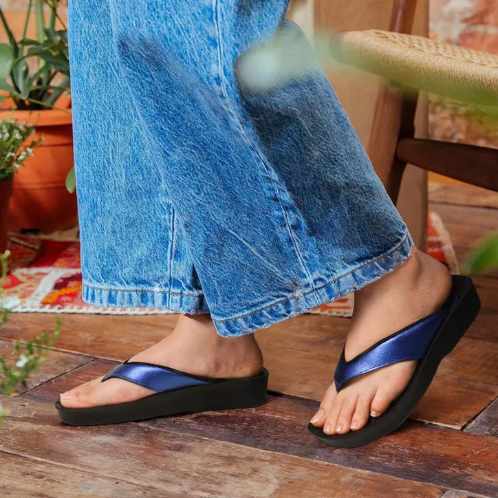 Person wearing blue sandals on a wooden floor
navy flip flops womens
flip flops in navy