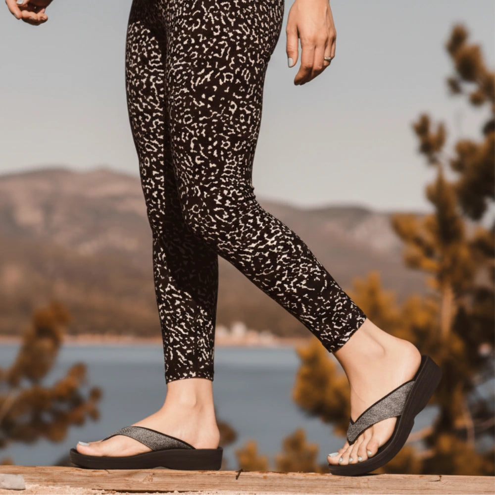 Person wearing leopard print leggings and sandals with a scenic background of mountains and water.
sandals with metatarsal support​